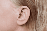Oticon More Hörgerät, Modell miniRITE R, Farbe Hellgrau, Foto aus einem 90°-Winkel aufgenommen, Nahaufnahme am Ohr, Frau Hörgeräte mit Auzen unbegrenzter Service